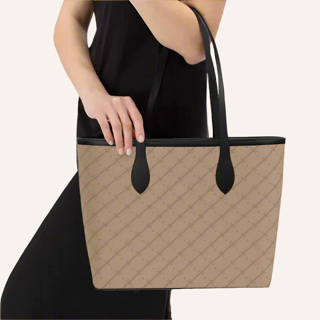A handbag with a structured profile and open-top design, featuring a neutral color palette and a textured surface. The handbag has magnetic closure and two interior pockets, with a faux suede interior lining.