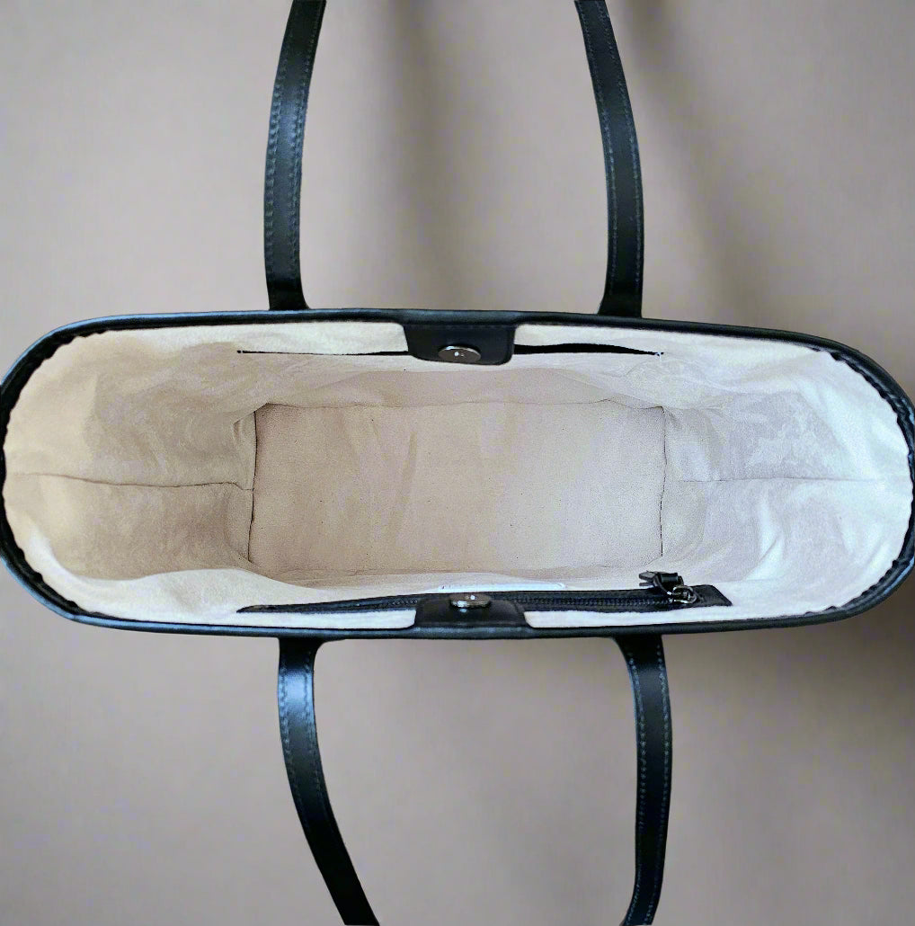 An aerial view of the shopper bag with the clasp opened, revealing two inside compartments on opposite sides