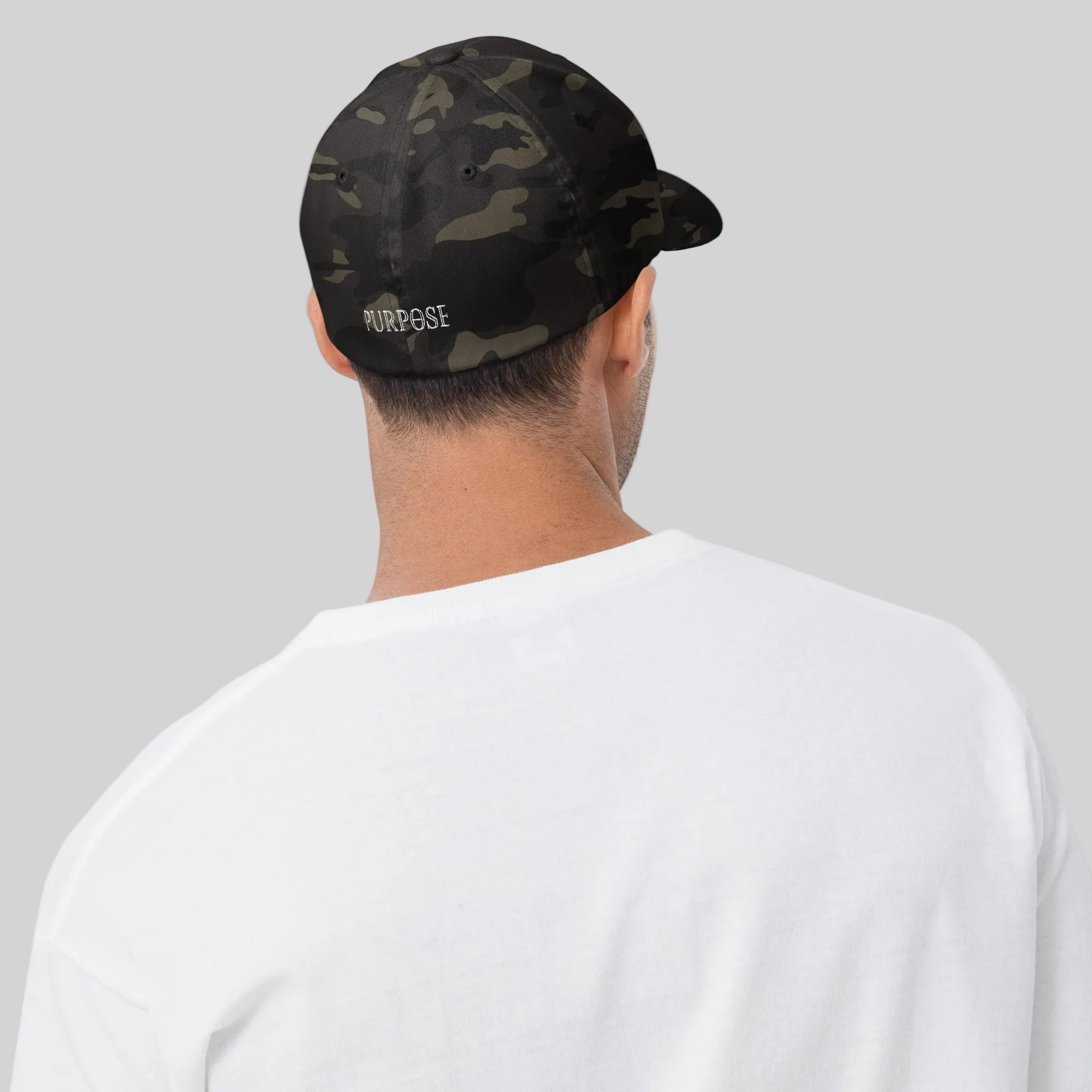 Man wearing a black camouflage cap with 'PURPOSE' text on a plain background