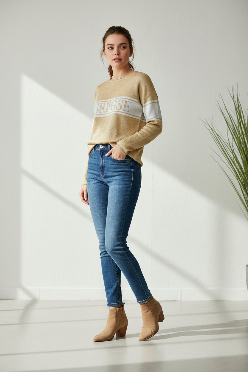 The beige sweater with two narrow white stripes and wide center stripe along the chest and upper arms, is displayed against a white background. The word "Purpose" is written in large, beige, capital letters on the center chest stripe.