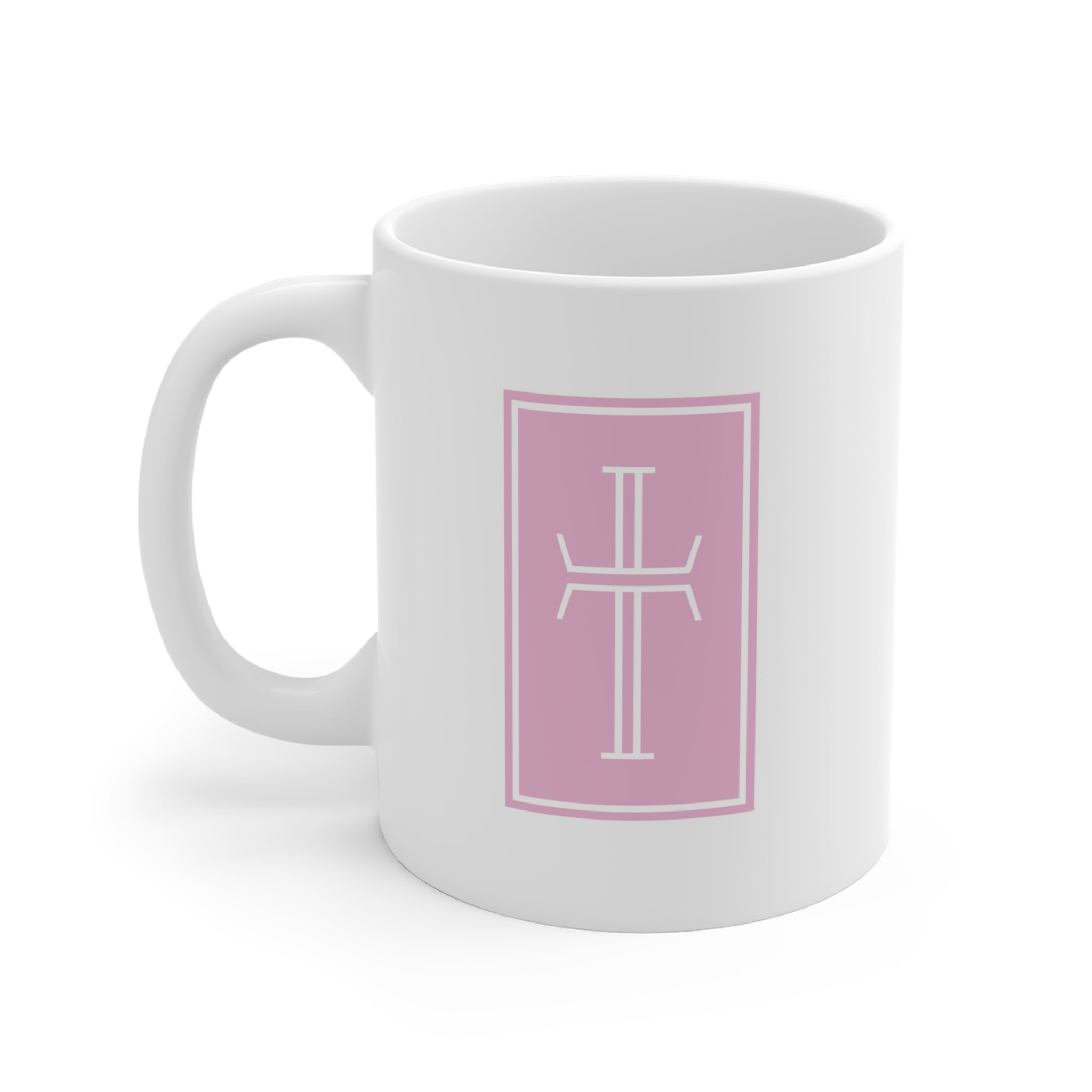 Front of a white mug displaying a white cross against a pink topaz background.