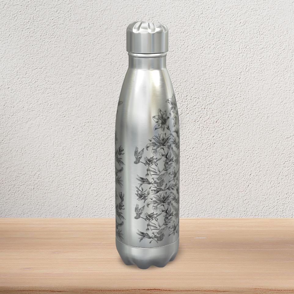 A stainless steel water bottle with stainless steel screw cap stands on a pine-wood console. It displays the semi-profile view of a black floral and dove pattern, revealing a blank seam along the vertical edge that delineates the front image from the back image.