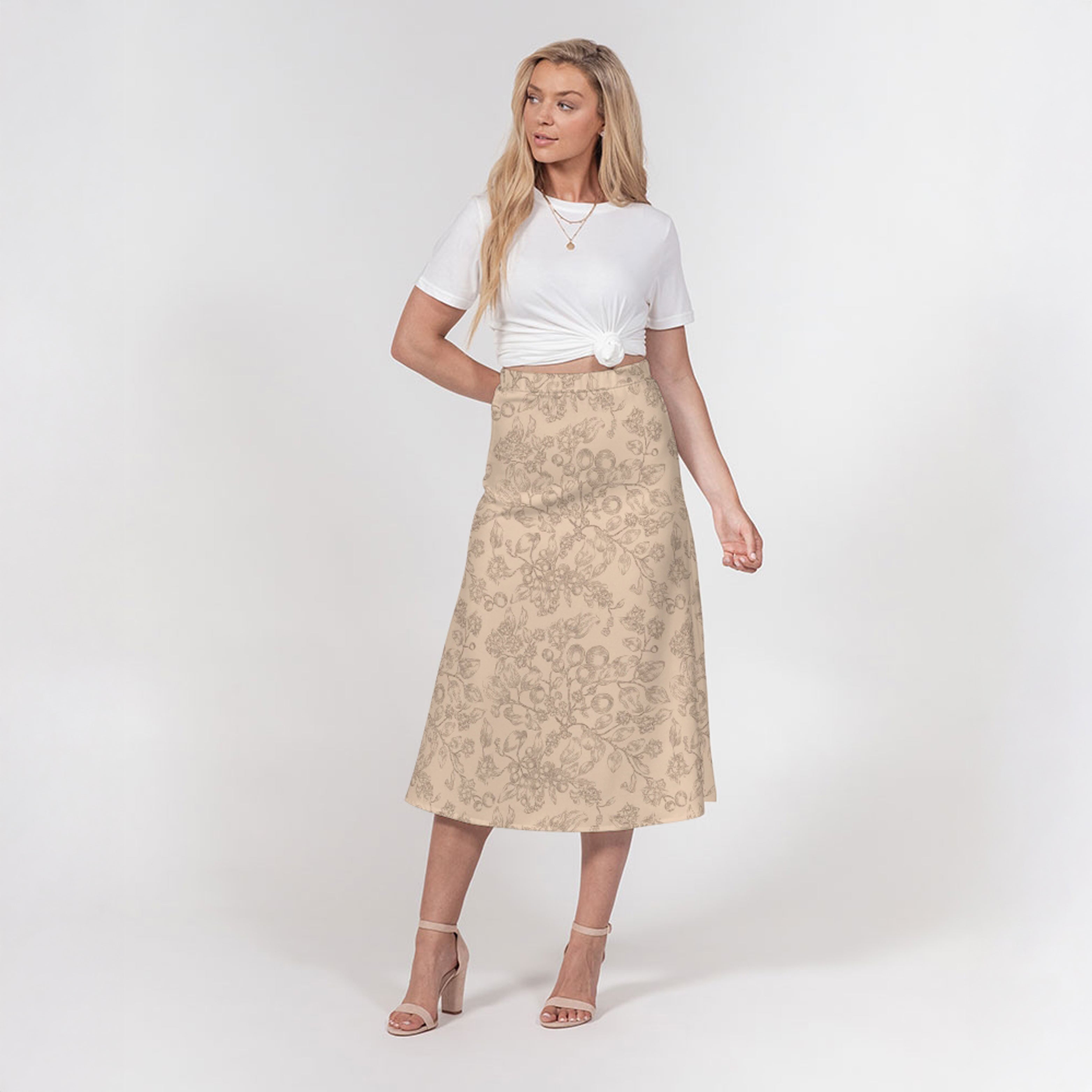 Woman wearing a white top and beige floral skirt on a white background