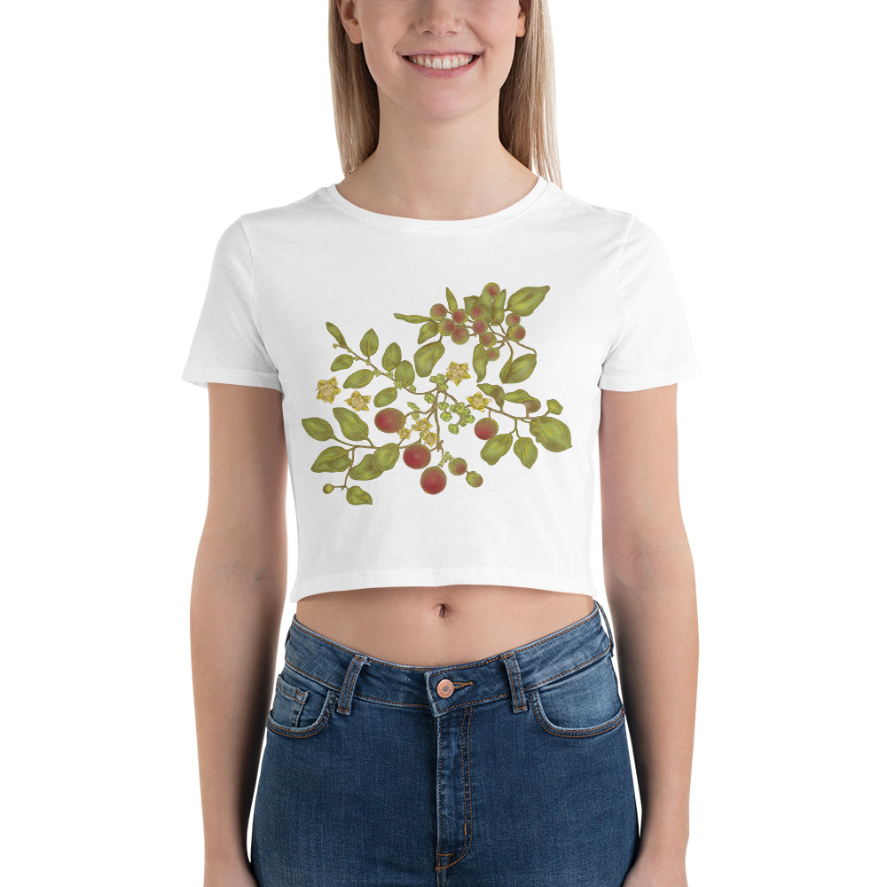 The front upper half of female model wearing a white cropped tee shirt with a floral image of a plant with various green, red, and yellow tones.