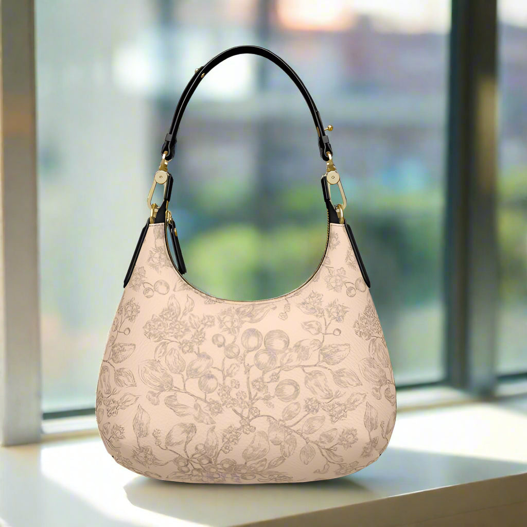 Small beige handbag with brown floral pattern, black handle, and metal hardware
