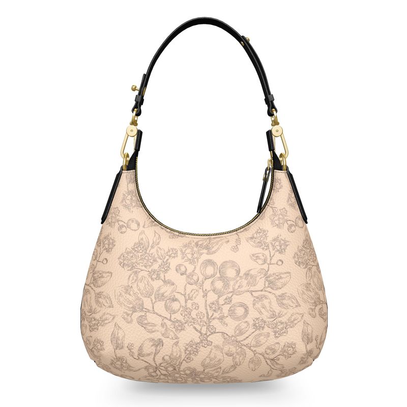 Back side of beige handbag with floral pattern, black leather handle, and gold accents on a white background. Christian handbag.