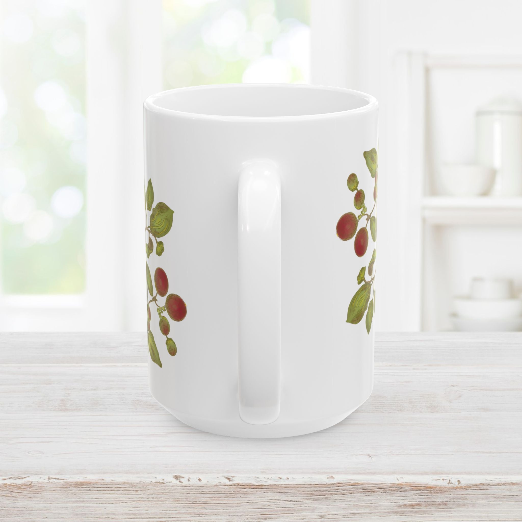 Back side with handle of white mug with floral, leaf, and berry design on a wooden surface.
