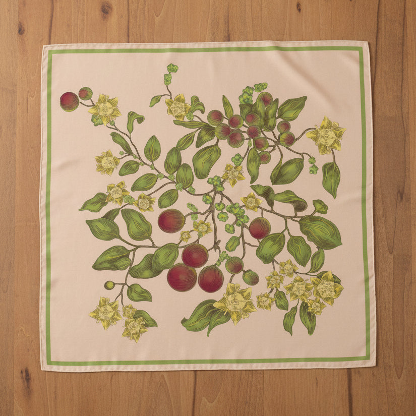 Square silk scarf on a table with Christian floral and leaf pattern. Christian accessory.